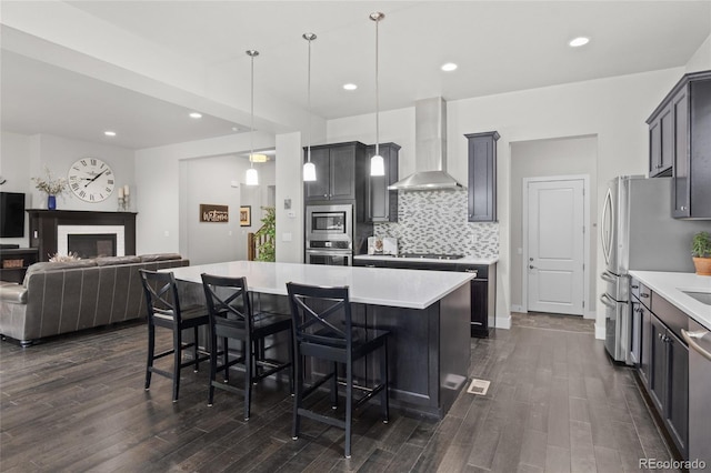 1867 W 137th Ln, Broomfield, CO 80023 - kitchen with wall chimney exhaust hood, stainless steel appliances, tasteful backsplash, light countertops, and open floor plan