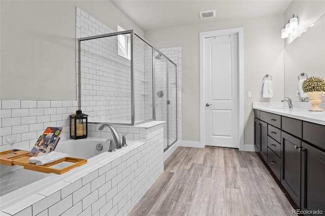 1867 W 137th Ln, Broomfield, CO 80023 - full bathroom with a garden tub, double vanity, a shower stall, and wood finished floors