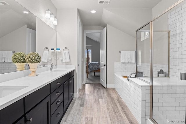 1867 W 137th Ln, Broomfield, CO 80023 - ensuite bathroom with vaulted ceiling, wood finished floors, double vanity, a bath, and a shower stall