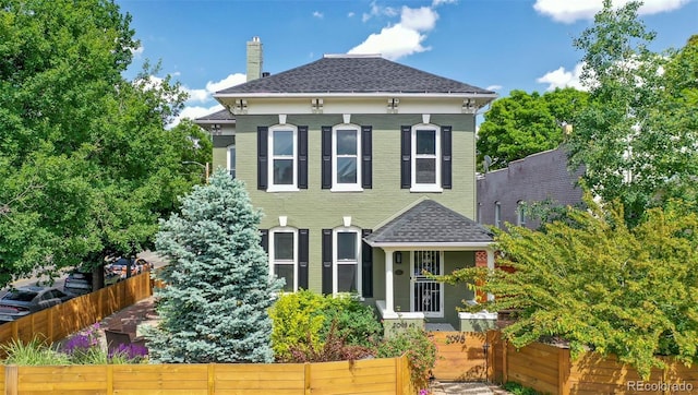 2098 N Clarkson St, Denver, CO 80205 - rear view of property with a fenced front yard, a shingled roof, and a chimney