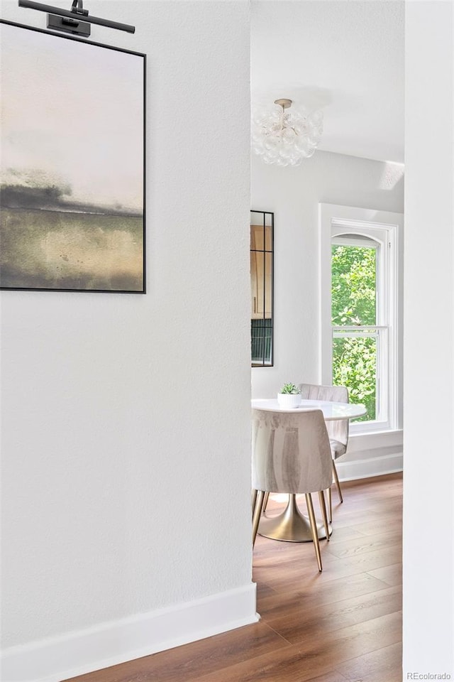 2098 N Clarkson St, Denver, CO 80205 - hallway with baseboards, wood finished floors, and a chandelier