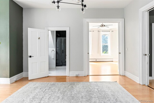 2098 N Clarkson St, Denver, CO 80205 - unfurnished bedroom with wood finished floors, a baseboard radiator, baseboards, and ensuite bathroom