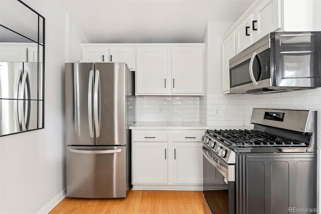 2098 N Clarkson St, Denver, CO 80205 - kitchen featuring appliances with stainless steel finishes, light wood-type flooring, white cabinets, and light countertops