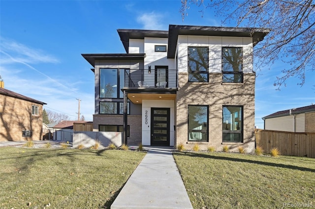 contemporary home with a balcony and a front lawn