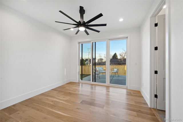 empty room with ceiling fan and light hardwood / wood-style flooring