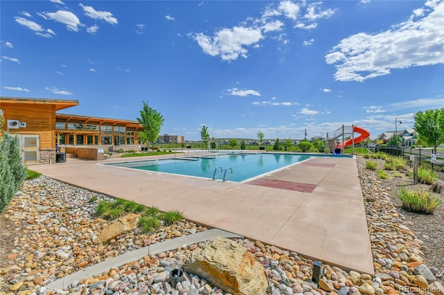 1086 Highlands Dr, Erie, CO 80516 - community pool featuring a water slide, fence, and a patio