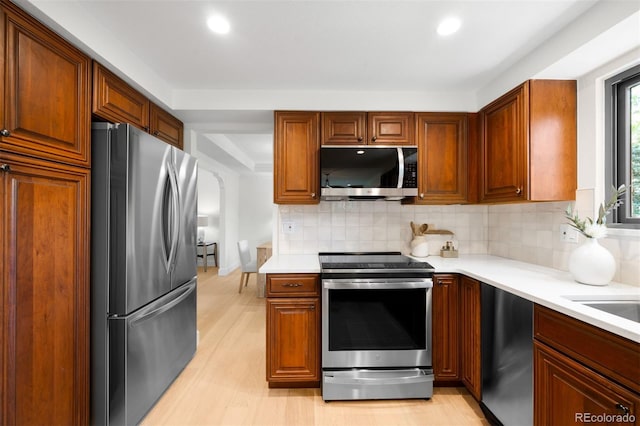 7308 S Steele Cir, Centennial, CO 80122 - kitchen featuring appliances with stainless steel finishes, light countertops, backsplash, recessed lighting, and light wood-style flooring