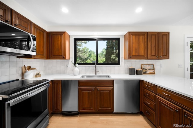 7308 S Steele Cir, Centennial, CO 80122 - kitchen with appliances with stainless steel finishes, light countertops, backsplash, light wood-style flooring, and recessed lighting