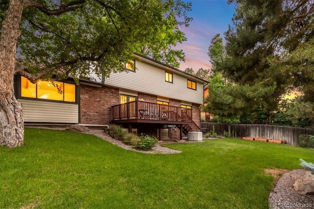 7308 S Steele Cir, Centennial, CO 80122 - back of house at dusk featuring a deck, brick siding, a fenced backyard, and stairs