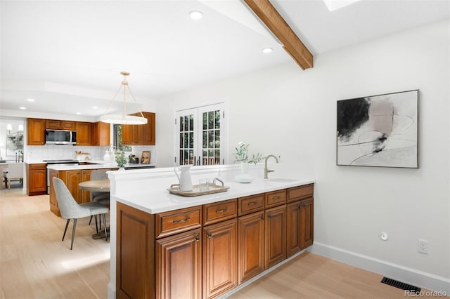 7308 S Steele Cir, Centennial, CO 80122 - kitchen featuring appliances with stainless steel finishes, light wood-type flooring, brown cabinetry, a peninsula, and light countertops