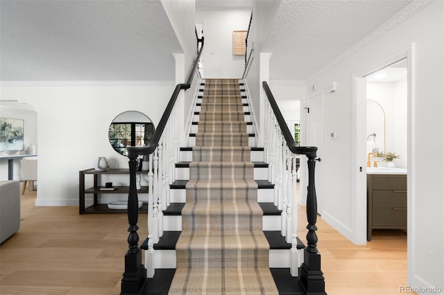 7308 S Steele Cir, Centennial, CO 80122 - stairs featuring wood finished floors, a textured ceiling, and ornamental molding