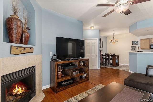 7440 S Blackhawk St Unit 2-106, Englewood, CO 80112 - living area featuring a tiled fireplace, baseboards, wood finished floors, and ceiling fan with notable chandelier