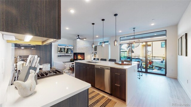 930 Blue River Pkwy Unit 622, Silverthorne, CO 80498 - kitchen featuring stainless steel dishwasher, dark brown cabinetry, a sink, modern cabinets, and light countertops