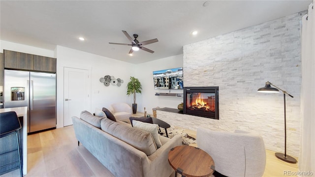 930 Blue River Pkwy Unit 622, Silverthorne, CO 80498 - living room featuring light wood-type flooring, ceiling fan, a stone fireplace, and recessed lighting