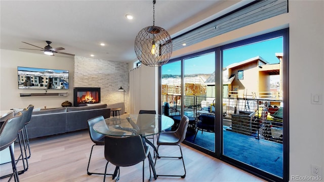 930 Blue River Pkwy Unit 622, Silverthorne, CO 80498 - dining space featuring light wood finished floors, a ceiling fan, a stone fireplace, and recessed lighting