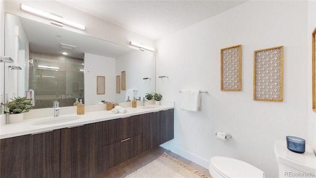 930 Blue River Pkwy Unit 622, Silverthorne, CO 80498 - full bathroom with toilet, a stall shower, baseboards, double vanity, and wood finished floors