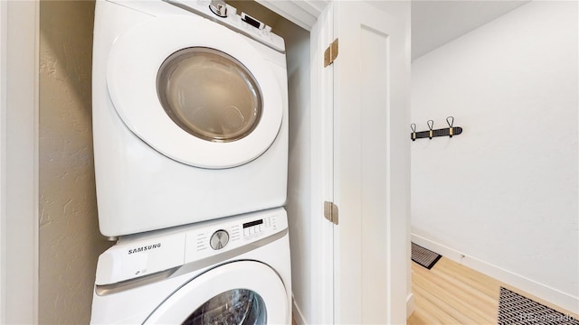 930 Blue River Pkwy Unit 622, Silverthorne, CO 80498 - clothes washing area featuring estacked washer and dryer, light wood-style floors, and baseboards