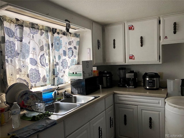 9260 County Road 133, Simla, CO 80835 - kitchen with light countertops, white cabinetry, a sink, and a textured ceiling