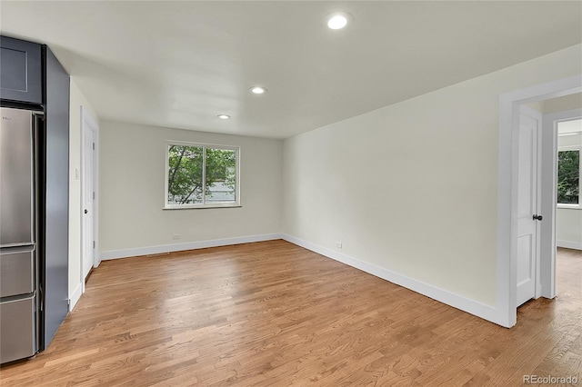 unfurnished room featuring healthy amount of natural light, baseboards, light wood finished floors, and recessed lighting