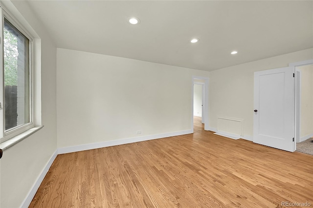 empty room featuring light wood-style flooring, baseboards, and recessed lighting