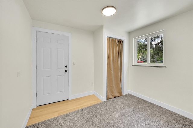 foyer with light carpet and baseboards