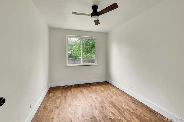 empty room featuring light wood finished floors, ceiling fan, and baseboards