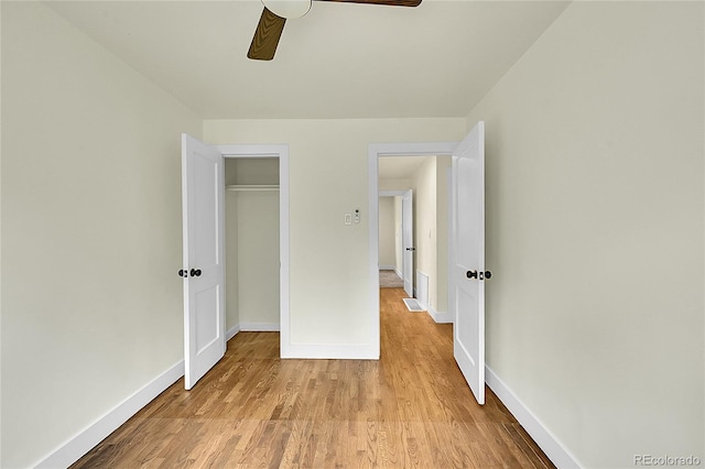unfurnished bedroom with wood finished floors, baseboards, ceiling fan, and a closet
