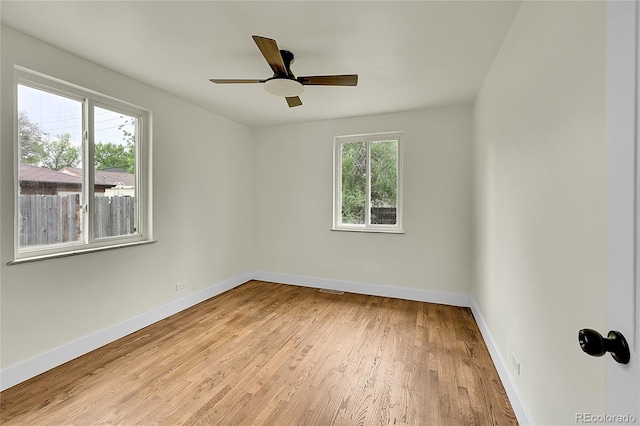 unfurnished room featuring wood finished floors, baseboards, and a ceiling fan