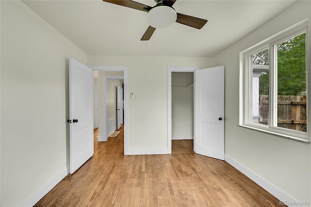 unfurnished bedroom with baseboards, light wood-style flooring, a ceiling fan, and a closet