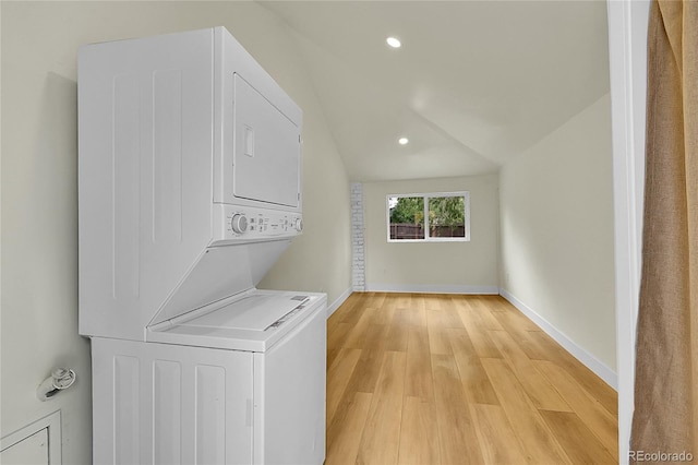 laundry area featuring stacked washer and clothes dryer, light wood finished floors, recessed lighting, and baseboards