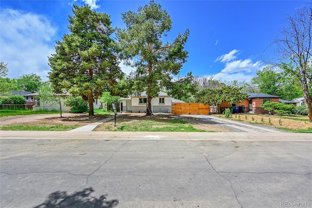 obstructed view of property with driveway and fence