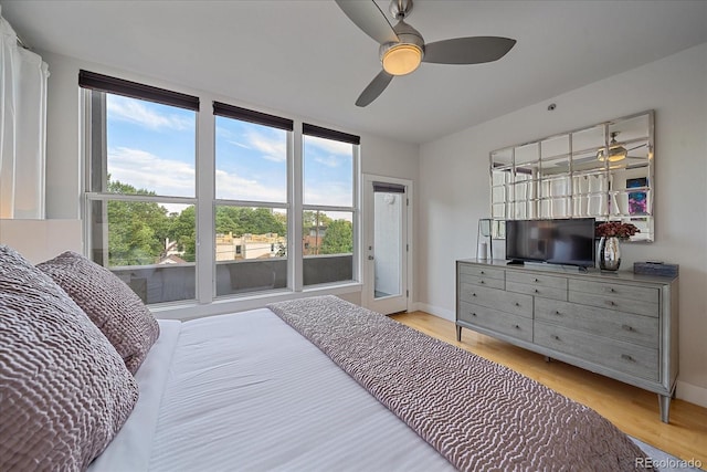 bedroom featuring ceiling fan, multiple windows, and light wood-type flooring