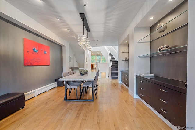 dining room featuring a baseboard radiator, built in features, and light wood-type flooring