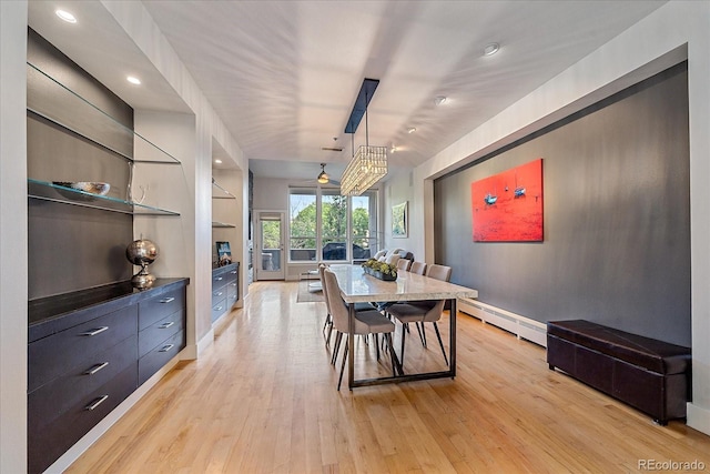 dining space featuring a baseboard heating unit and light hardwood / wood-style floors