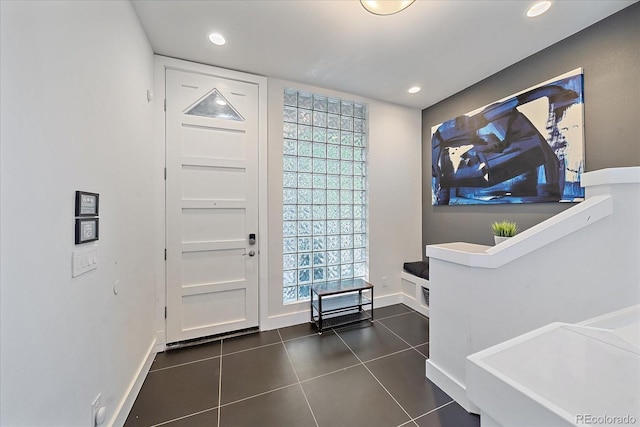 foyer with dark tile patterned flooring and a healthy amount of sunlight