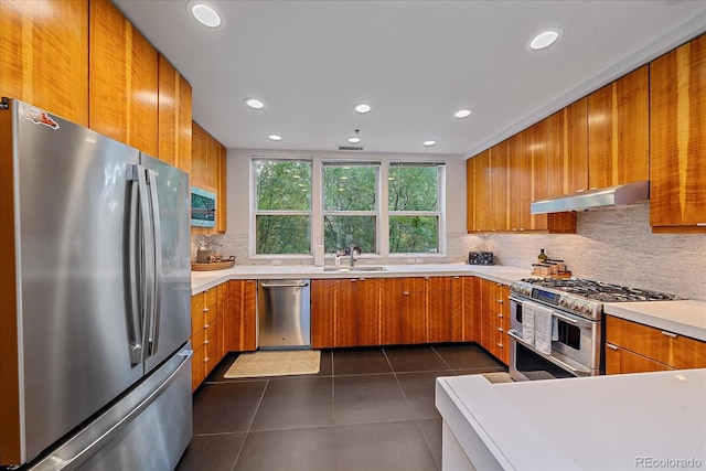 kitchen with tasteful backsplash, sink, dark tile patterned floors, and appliances with stainless steel finishes