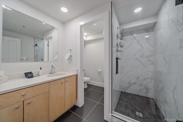 bathroom featuring an enclosed shower, vanity, tile patterned floors, and toilet