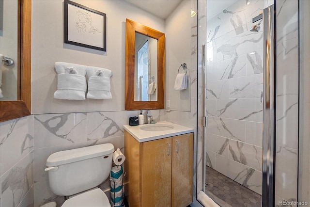 bathroom with walk in shower, vanity, toilet, and tile walls