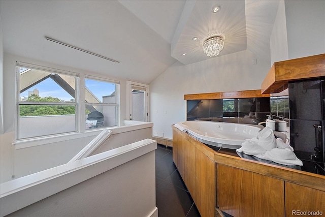 bathroom featuring lofted ceiling, sink, tile patterned flooring, a notable chandelier, and a tub to relax in