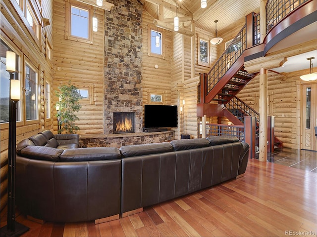 living room with a healthy amount of sunlight, hardwood / wood-style floors, a high ceiling, and wooden ceiling