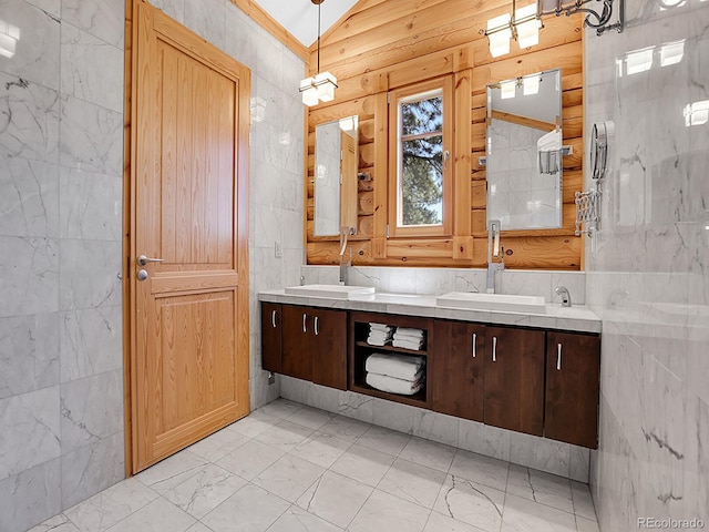 bathroom featuring vanity, vaulted ceiling, and tile walls