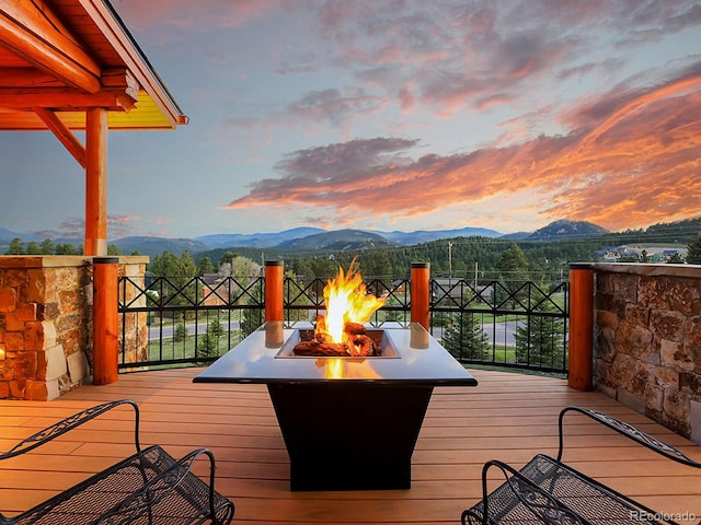 deck at dusk with a mountain view and a fire pit