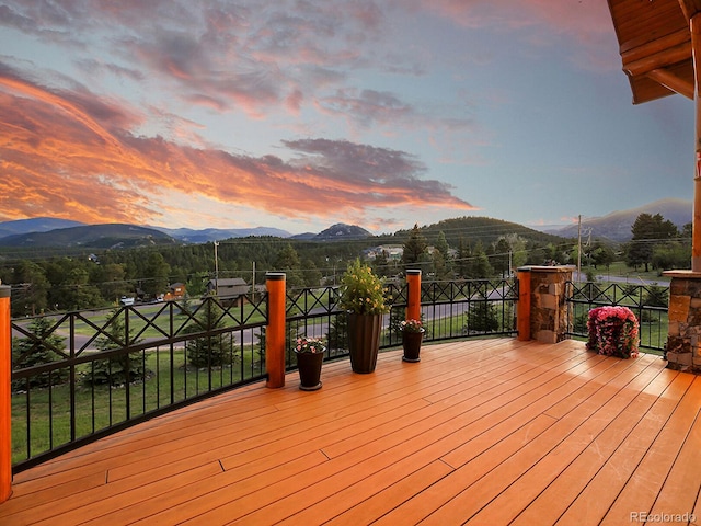 deck at dusk featuring a mountain view