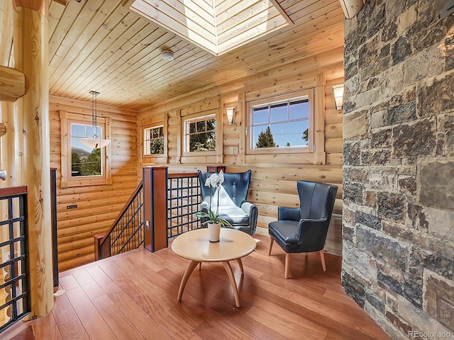 living area with wood-type flooring, rustic walls, and wooden ceiling