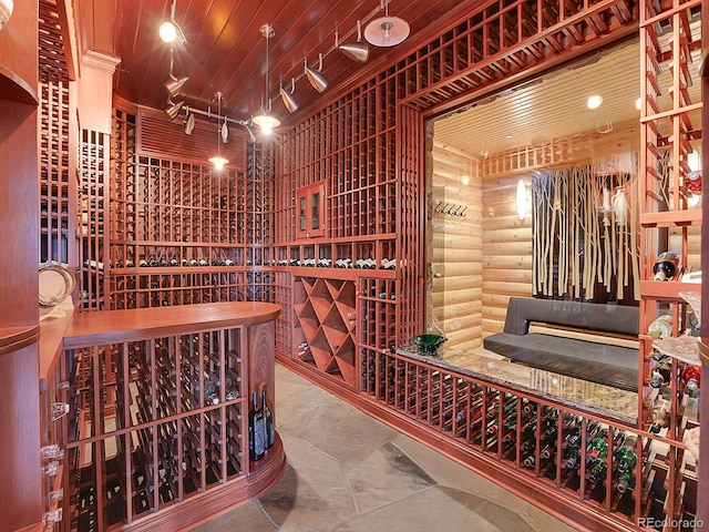 wine cellar featuring rustic walls and wooden ceiling