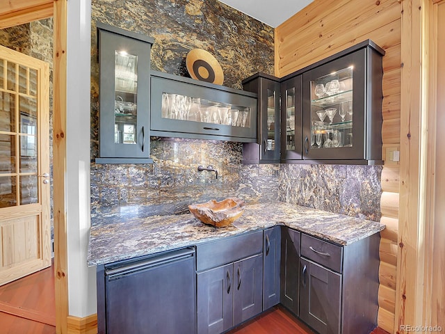 bar featuring backsplash and stone counters