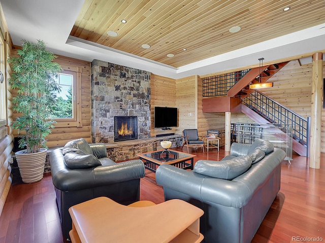 living room with hardwood / wood-style floors, rustic walls, wood ceiling, and a tray ceiling