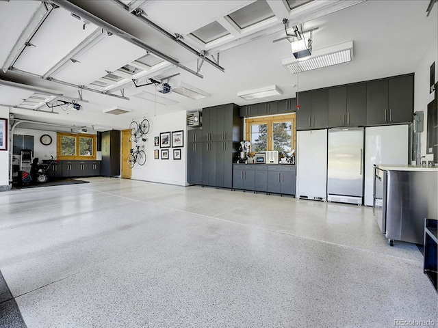 garage featuring stainless steel built in refrigerator, a garage door opener, and white fridge