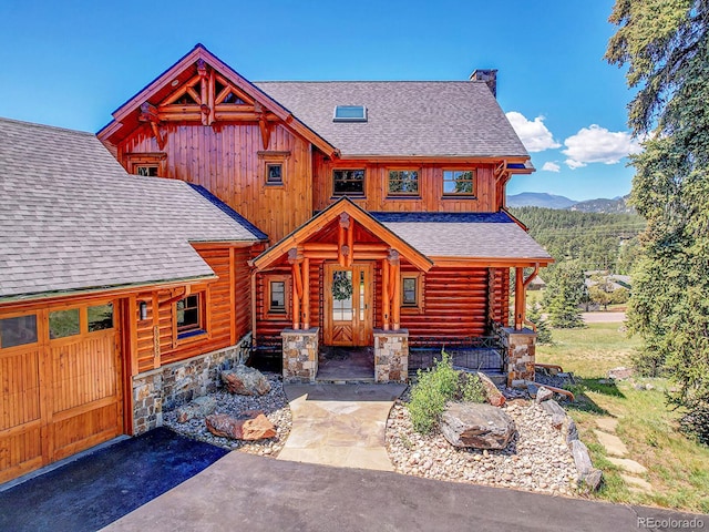 log home featuring a mountain view, a garage, and covered porch