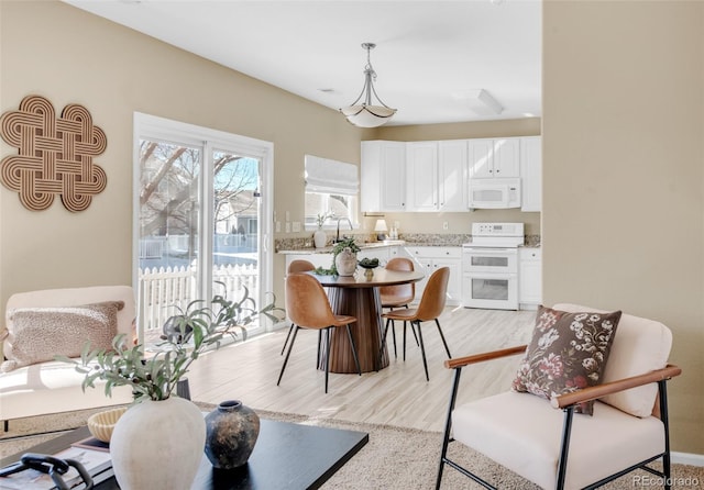 dining room featuring light wood finished floors and baseboards